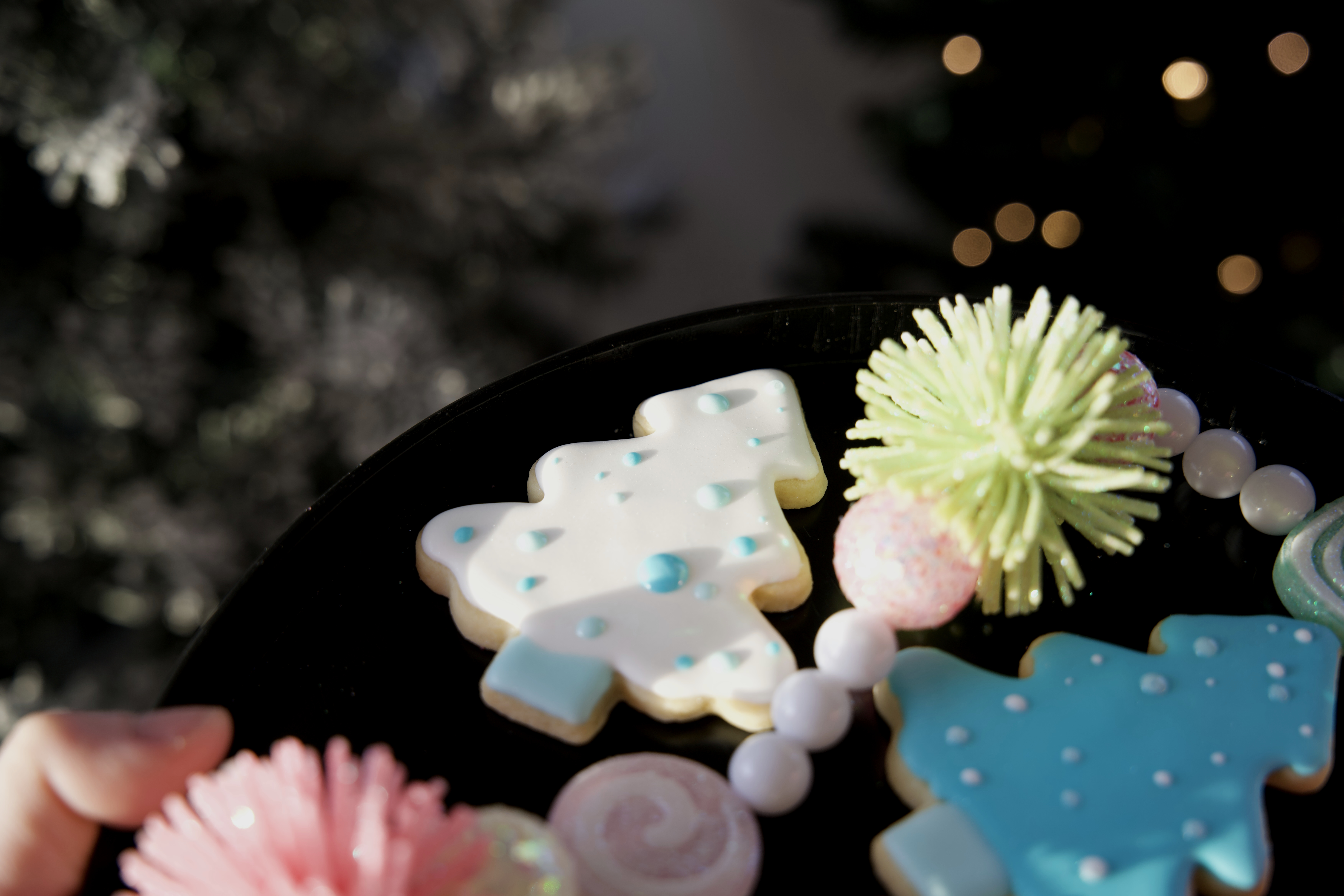 Sugar cookie decorated with white icing and holiday decor around. 